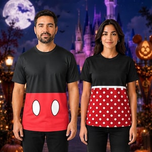 May include: Two short-sleeved t-shirts with black upper sections. One shirt features a red lower section with two large white oval shapes. The other shirt features a red lower section with a white polka dot pattern and a horizontal white stripe.