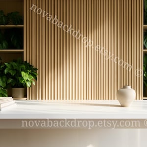 Może przedstawiać: Biały stół ze stosem książek i beżowym wazonem. Za stołem znajduje się drewniana ściana z listew i półki wypełnione doniczkowymi zielonymi roślinami. Widoczny jest tekst "novabackdrop.etsy.com".