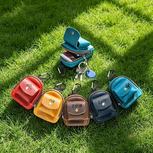 Puede incluir: Seis pequeñas bolsas de cuero de colores con mosquetones de metal y cierres de botón a presión. Las bolsas son rojas, amarillas, marrones, azul oscuro y dos tonos de turquesa. Algunas tienen grabados como Jak, TOM, Love o iconos.