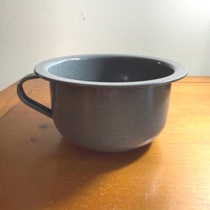 Puede incluir: Un juego de tres tazas de cerámica con un acabado mate moteado. Las tazas son en tonos crema, gris claro y gris oscuro. Cada taza tiene un diseño simple y minimalista, perfecto para café o té.