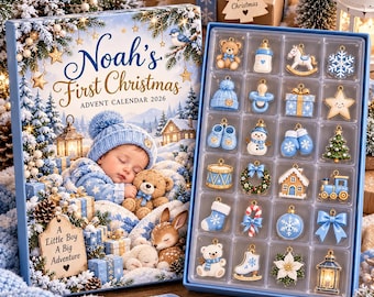 May include: A Noah's First Christmas 2026 advent calendar box featuring a sleeping baby in a blue hat and a tray of twenty-four small, colorful holiday-themed metal charms including a teddy bear, baby bottle, snowman, and train.