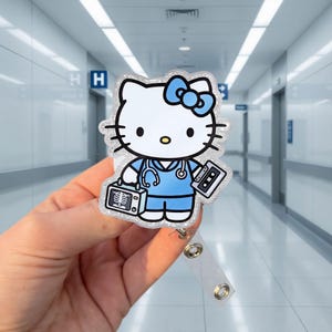 Puede incluir: Un portatarjetas de acrílico con purpurina que muestra un personaje de dibujos animados vestido con uniforme médico azul y estetoscopio, sosteniendo una máquina de rayos X portátil y un casete. El personaje tiene un lazo azul y acabado brillante.