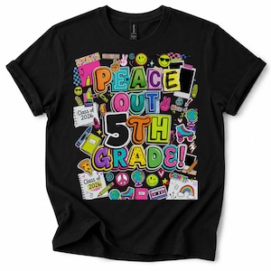 Op de afbeelding: Zwart t-shirt met een kleurrijk ontwerp. De opdruk luidt "PEACE OUT 5TH GRADE!" in heldere letters, vergezeld van schoolgerelateerde illustraties, smileys en een regenboog, ideaal voor een leerling.
