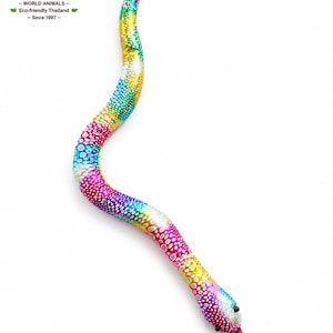 Op de afbeelding: Een kleurrijk knuffelslangspeelgoed met een regenboogpatroon van roze, blauw, geel en groen. De slang heeft kleine zwarte ogen en een rode tong. Het speelgoed is gemaakt door JUMARIN, een milieuvriendelijk bedrijf uit Thailand.