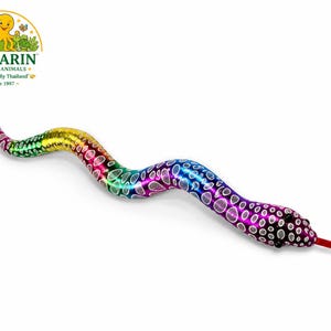 May include: A flexible toy snake featuring a vibrant rainbow gradient pattern of purple, blue, green, and yellow. The body is covered in a repeating white oval spot design with a metallic sheen. It has two small black eyes and a red forked tongue.