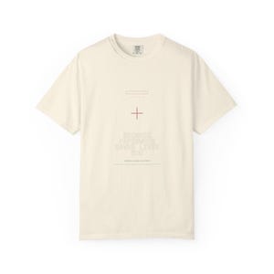 以下が含まれることがあります： クリーム色のTシャツ。ミニマルなデザインで、プラス記号の付いた円と「BECAUSE PAPERWORK SAVES LIVES TOO」のテキストが特徴です。柔らかい素材で作られており、クルーネックです。