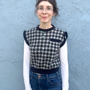 Puede incluir: Un chaleco con estampado de pata de gallo en blanco y negro, con ribete y bolsillo azul marino. El chaleco tiene peque&ntilde;os adornos azul claro y se lleva sobre una camisa blanca de manga larga y vaqueros azules.