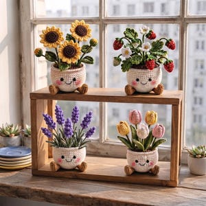 May include: Four crocheted potted plants arranged on a wooden shelf. Each white pot features a smiling face with pink cheeks and small feet. The plants include yellow sunflowers, red strawberries with white flowers, purple lavender, and pastel tulips.
