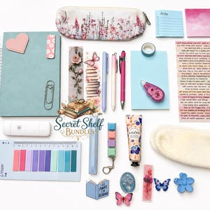 May include: An assortment of stationery items, including a floral pencil case, pens, sticky notes, and a reading log. The items are arranged on a white surface, with a light blue notebook and a pink heart-shaped magnet. The text "Secret Shelf Bundles" is visible.