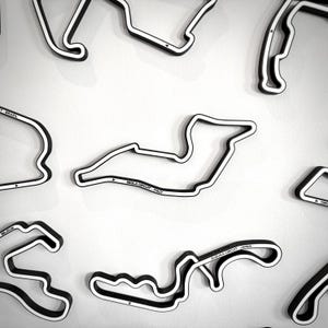 Könnte beinhalten: Eine weiße Keramik-Tasse mit schwarzem Henkel und dem Text "But First, Coffee" in schwarzer, handschriftlicher Schrift. Die Tasse steht auf einer weißen Oberfläche.