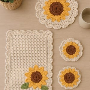Può includere: Una collezione di articoli all'uncinetto fatti a mano con un motivo a girasole. Il set include un sottopiatto, due sottobicchieri e un tappetino rotondo più grande. I girasoli hanno petali gialli e centri marroni, con foglie verdi sul sottopiatto.