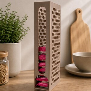 May include: A tall, rectangular, light brown plastic storage dispenser featuring a honeycomb-patterned side and a vertical front opening. The dispenser is filled with several small, rectangular, pink-wrapped food items stacked vertically.