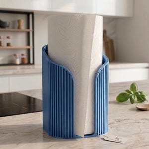 May include: A blue vertical paper towel holder with a ribbed exterior design, holding a roll of white paper towels with a subtle leaf pattern. A small rectangular tag is attached to the base of the holder.