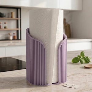 May include: A cylindrical lavender paper towel holder with a vertical ribbed texture, containing a roll of white paper towels embossed with a leaf pattern. A small rectangular tag is attached to the base of the holder.