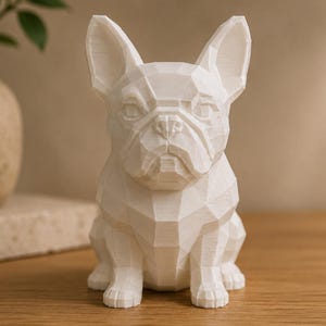May include: A white, low-poly geometric sculpture of a French Bulldog. The figure features sharp, angular facets that define the dog's ears, snout, and body shape, creating a structured, multi-faceted appearance with a matte finish.