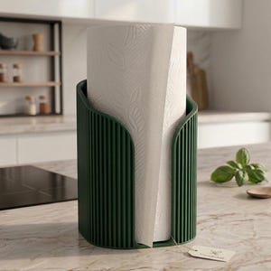 May include: A dark green, vertically ribbed paper towel holder with a cylindrical shape, containing a roll of white paper towels embossed with a delicate leaf pattern. A small, rectangular, light-colored tag is attached to the base.