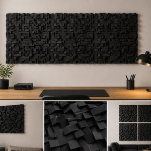 May include: A set of three rectangular black wall panels featuring a three-dimensional geometric block pattern. The panels are mounted horizontally on a wall above a wooden desk, showcasing a textured surface with varying depths and shadows.