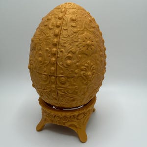 May include: A set of three ceramic mugs with a speckled, matte finish. The mugs are in shades of cream, light gray, and dark gray. Each mug has a simple, minimalist design and a rounded handle.