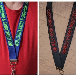 May include: Two blue lanyards with silver clasps and key rings. One lanyard has the text "GGT ROOFING & CONSTRUCTION" in green lettering. The other lanyard has the text "EQUESTRIAN CANADA STEWARD" in red lettering.