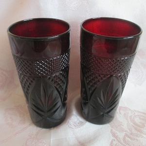 May include: Two red glass tumblers with a diamond pattern and leaf design.