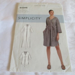 May include: Simplicity sewing pattern R10598 for a dress with a V-neck, long sleeves, and a tie belt. The pattern includes three different views: a long dress, a short dress, and a short-sleeved dress.