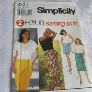 May include: Simplicity sewing pattern for a 2-hour sarong skirt. The pattern envelope features illustrations of women wearing sarongs in various colors and patterns. The text "2 HOUR sarong skirt" is prominently displayed.