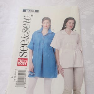 May include: A sewing pattern titled "see & sew" featuring two women modeling different shirt and pants outfits. One outfit is a light blue button-down shirt with white pants, and the other is a white shirt with beige pants. The pattern includes the text "YES! It's easy".