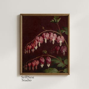 May include: A framed oil painting print featuring two arching stems of pink and white bleeding heart flowers against a dark, moody burgundy background. The artwork is encased in a thin, metallic gold frame with visible brushstroke textures.