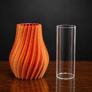 Può includere: Un vaso arancione testurizzato con un motivo a coste verticali a spirale e un'ampia apertura, accompagnato da un inserto cilindrico in vetro trasparente progettato per essere inserito nel vaso per contenere acqua o composizioni floreali.