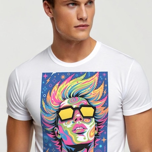 Puede incluir: Camiseta blanca con un vibrante gráfico de arte pop. El gráfico representa a una persona con cabello colorido, gafas de sol amarillas y un diseño multicolor en espiral. La obra de arte está sobre un fondo azul con detalles de estrellas y espirales.