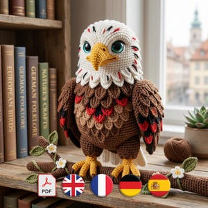 May include: A detailed crochet eagle, featuring a white head, brown body, and yellow beak and feet. The eagle has large blue eyes and is perched on a crocheted branch. The background includes books and a window view.