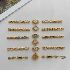 Op de afbeelding: Een collectie goudkleurige polshorloges en bijpassende metalen schakelarmbanden, gerangschikt in twee verticale kolommen. De horloges hebben ronde wijzerplaten in diverse kleuren, terwijl de armbanden zijn voorzien van ovale accenten en parels.