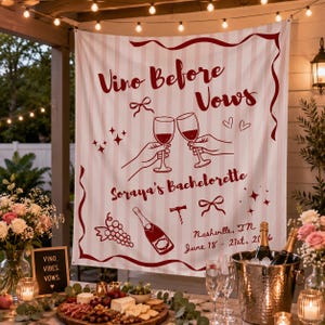 Op de afbeelding: Een wit en lichtroze gestreepte stoffen achtergrond met donkerrode tekst die Vino Before Vows, Soraya's Bachelorette, Nashville, TN, June 18-21, 2016 leest, met illustraties van wijnglazen, een fles, druiven en strikken.
