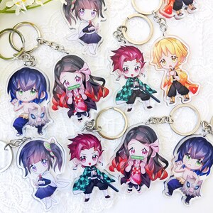 Könnte beinhalten: Sammlung von Schlüsselanhängern mit Anime-Charakteren. Jeder Schlüsselanhänger zeigt eine farbenfrohe, Chibi-artige Illustration eines Charakters mit großen Augen und detaillierten Outfits. Schlüsselanhänger sind an silberfarbenen Schlüsselringen und Ketten befestigt.