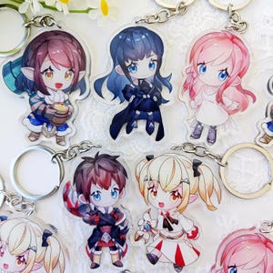 May include: Collection of anime-style character keychains. Each keychain features a colorful illustration of a character with large eyes and unique outfits. The keychains are attached to silver key rings and chains.