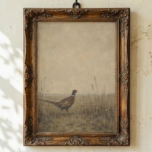 Puede incluir: Una impresión de arte mural rectangular que muestra un faisán de pie en un campo de hierba alta bajo un cielo apagado, encerrada en un marco de madera marrón oscuro ornamentado con detalles tallados y un pequeño gancho de metal arriba.