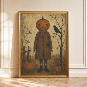 May include: A framed wall art print depicting a figure with a pumpkin head wearing a brown coat, standing in a field with a black bird perched on a bare tree. Two orange pumpkins sit on the ground near the figure, with a wooden fence in the background.