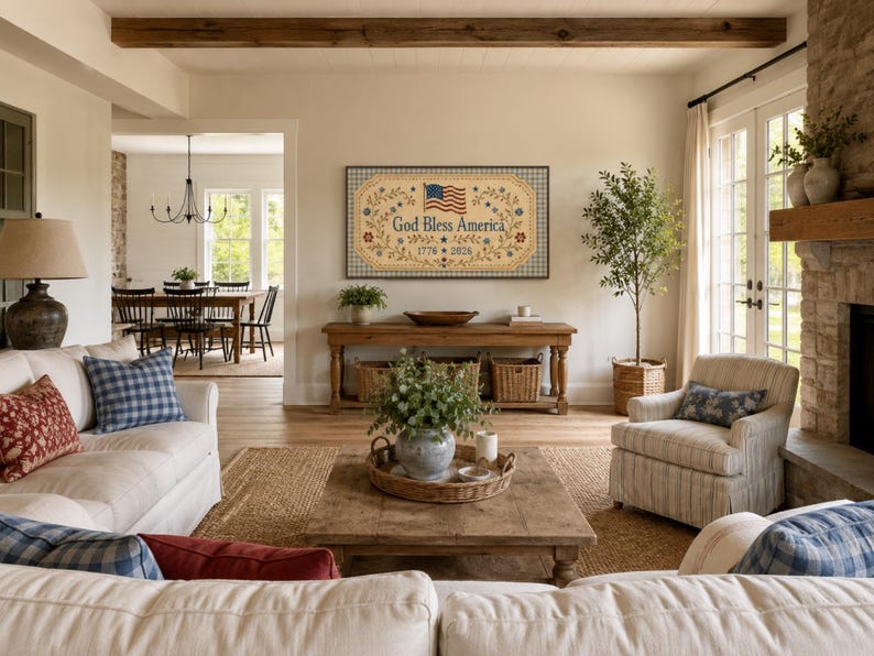 Pu&ograve; includere: Una targa da parete rettangolare con sfondo beige e bordo a scacchi blu. Il testo 'God Bless America' &egrave; centrato in blu, affiancato da tralci floreali e una piccola bandiera americana. Le date '1776' e '2026' appaiono sotto il testo.