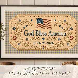 Pu&ograve; includere: Un ricamo a punto croce incorniciato con sfondo beige e bordo a quadretti blu. Il disegno presenta una bandiera americana che sventola, il testo God Bless America e gli anni 1776 e 2026, decorato con tralci floreali e stelle blu.