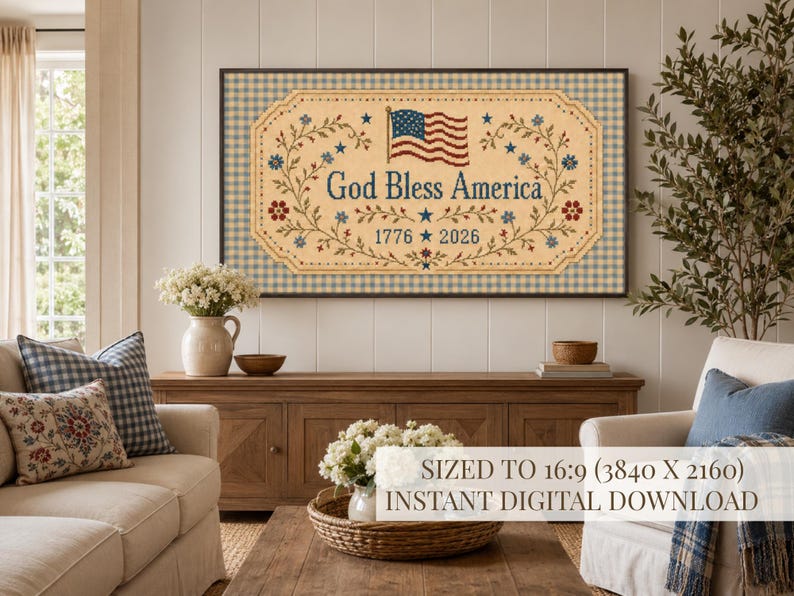 Pu&ograve; includere: Un quadro rettangolare con sfondo beige e bordo a quadretti blu e bianchi. Il testo God Bless America &egrave; centrato sopra gli anni 1776 e 2026, affiancato da tralci floreali, stelle e una piccola bandiera americana.