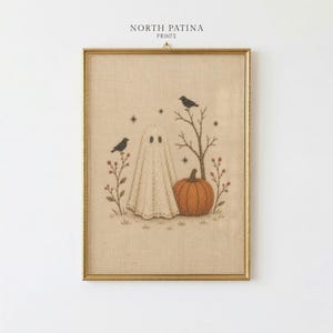 May include: A framed embroidery art piece on beige fabric featuring a white ghost, an orange pumpkin, two black birds, and bare branches. The text NORTH PATINA PRINTS is centered at the top. The design includes small star shapes and berry sprigs.