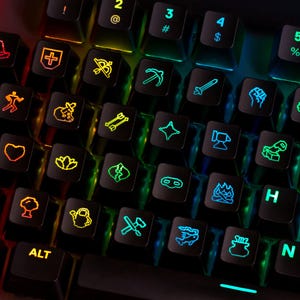 Pode incluir: Um teclado de computador preto com teclas retroiluminadas com ícones personalizados, incluindo um chapéu de feiticeiro, escudo, espada, fogueira e várias ferramentas. As teclas exibem um gradiente de arco-íris vibrante de luz.