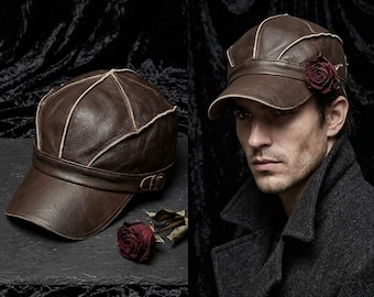 May include: Brown leather cap with a short brim and decorative stitching. The cap features a dark red rose accent. The cap is shown on a dark surface and also worn by a person wearing a dark coat.