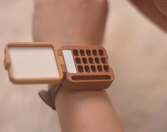 A 3D-printed watercolor palette for a watch-style wristband as a gift for him/her.