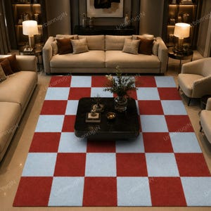May include: A large area rug with a red and light blue checkerboard pattern. The rug is rectangular and covers a large portion of the room, with furniture visible around it. The rug adds a bold, geometric element to the living space.