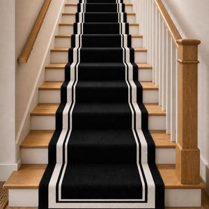 May include: A staircase with wooden steps and a black carpet runner. The runner has a white border and runs up the center of the stairs. The walls are painted a light beige, and the handrails are wood.