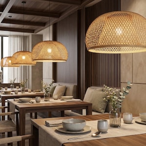 Puede incluir: Interior de restaurante con mesas de madera e iluminación colgante de mimbre. Las mesas están puestas con vajilla, manteles individuales neutros y arreglos florales. La iluminación crea un ambiente cálido. Las lámparas colgantes son de mimbre tejido.