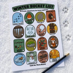 May include: A white paper sheet titled Winter Bucket List with 16 colorful illustrated icons depicting seasonal activities like animal tracks, a robin, a snowman, and a fox. Each icon has a checkbox. The text reads Cold Air, Warm Hearts! A pencil lies nearby.
