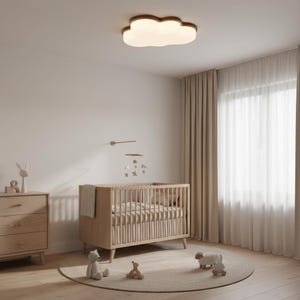 May include: A nursery room with a light wood crib, a matching dresser, and a cloud-shaped ceiling light. A mobile with stars hangs above the crib. The room has a neutral color palette with a round rug and stuffed animals.