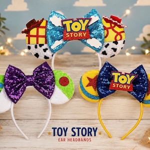 May include: Three headbands featuring Toy Story themes. The top headband has blue sequin ears with a cloud pattern, a central bow, and a Toy Story logo. The bottom left headband has green, white, and purple sequin ears. The bottom right has yellow and blue ears.